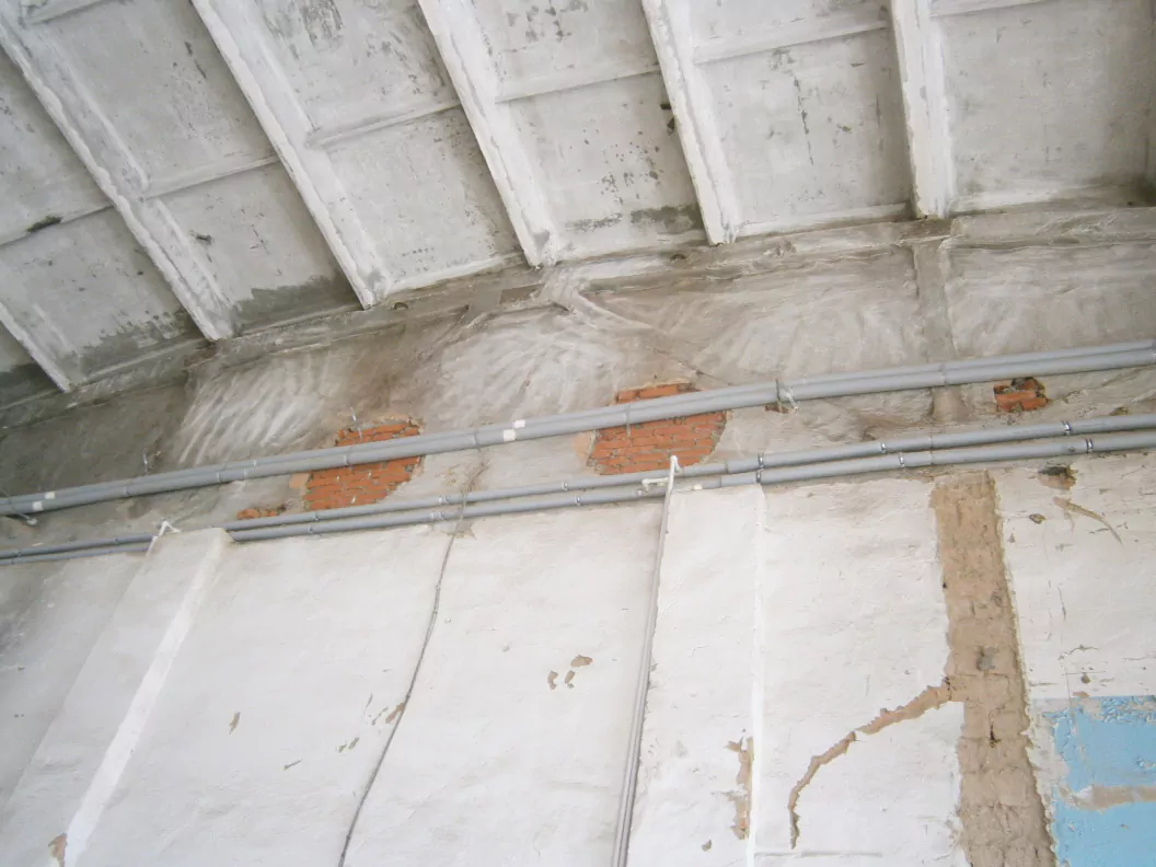 Поперечная кирпичная стена, разделяющая помещения в обследуемом здании, возведенная в месте опирания фермы на колонны